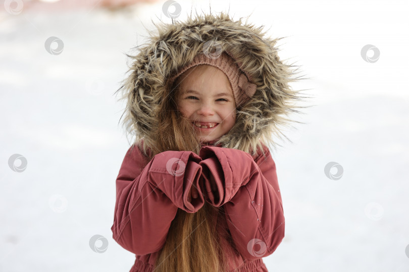 Скачать Портрет маленькой очаровательной девочки в зимней шапочке в заснеженном лесу фотосток Ozero