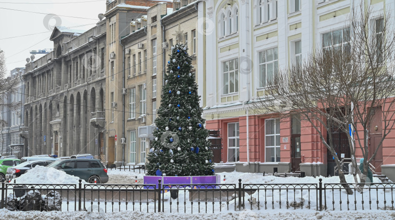 Скачать Рождественская елка на улице, украшенная рождественскими игрушками. Украшение к Новому году и Рождеству фотосток Ozero