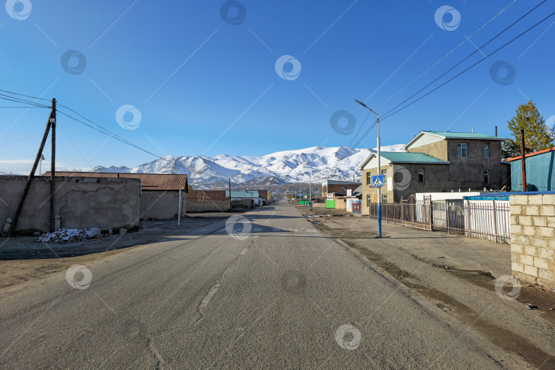 Скачать Северная Монголия. Утренний город - Ульгий. Дома на этой улице тянутся вдаль, к заснеженным вершинам гор. фотосток Ozero