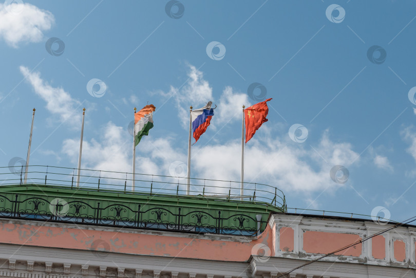 Скачать Россия, Санкт-Петербург, октябрь 2023 года: флаги Индии, России и Китая на крыше здания фотосток Ozero