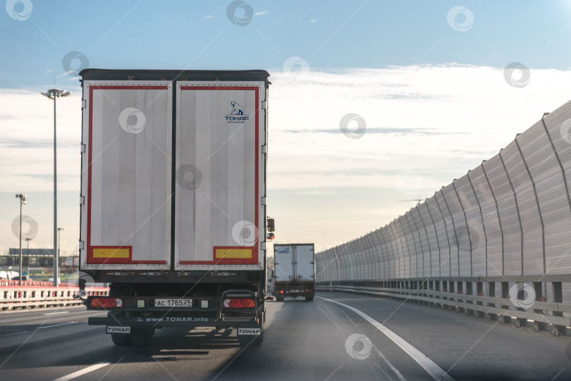 Скачать Россия, Санкт-Петербург, октябрь 2023 года: движение грузовых автомобилей по шоссе за пределами города фотосток Ozero