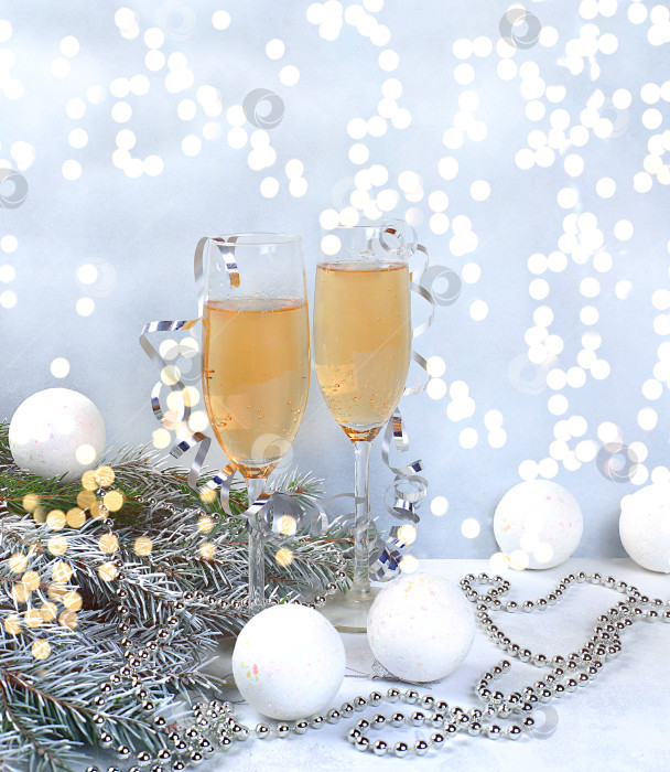 Скачать Два бокала шампанского на элегантном праздничном фоне с еловыми ветками и красивыми украшениями. Рождественский и новогодний макет для дизайна и демонстрации продукции, концепция Сочельника, фотосток Ozero