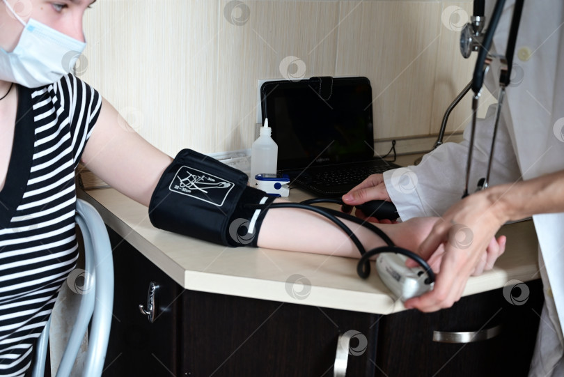 Скачать Врач измеряет кровяное давление пациента в медицинском кабинете. Концепция медицинских услуг фотосток Ozero