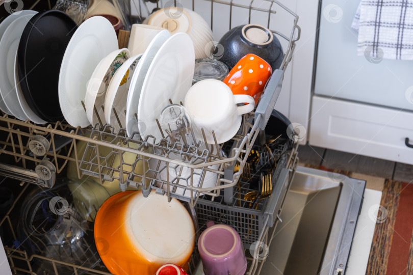 Скачать В посудомоечной машине много грязной посуды. Помощь хозяйке, экономия и экология. Уборка на кухне фотосток Ozero