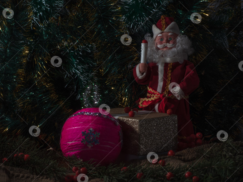 Скачать Дед Мороз под рождественской елкой с подарком в стиле ретро. Рождественская (новогодняя) открытка в темном ключе. Домашний минималистский декор фотосток Ozero