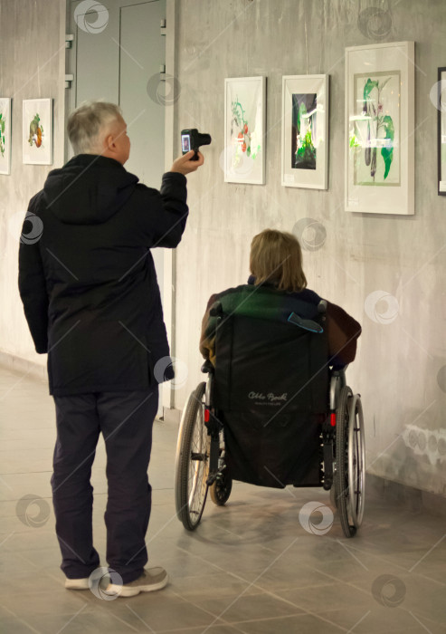 Скачать Женщина-инвалид на выставке картин. фотосток Ozero