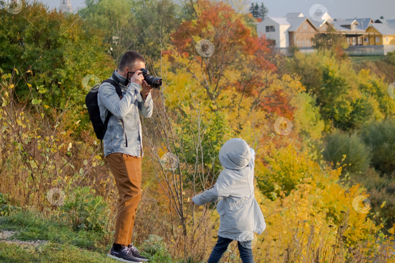 Скачать Мужчина фотографирует ребёнка на природе. фотосток Ozero