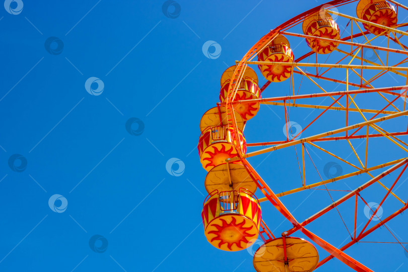 Скачать Желтое колесо обозрения на фоне голубого неба. Место для вашего текста фотосток Ozero