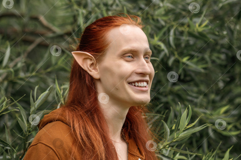 Скачать Артистичный эльф-мужчина с рыжими волосами и зелеными глазами в лесу фотосток Ozero