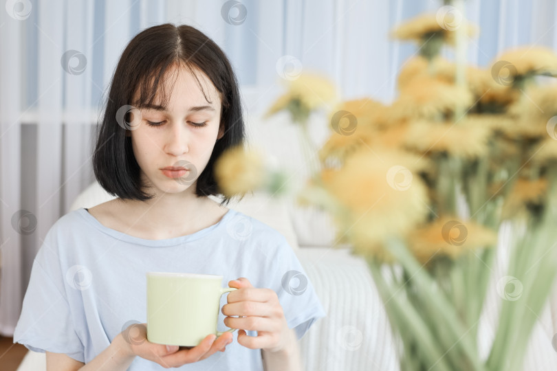 Скачать Молодая девушка пьет чай в гостиной фотосток Ozero