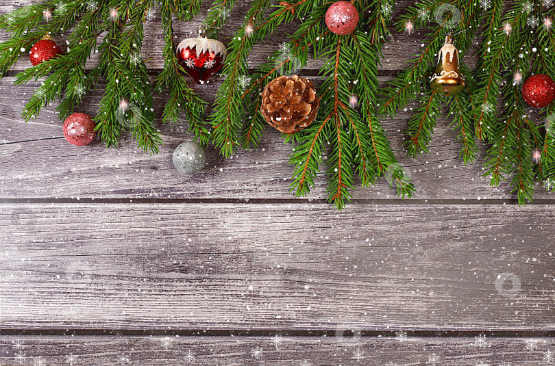Скачать Фон на Рождество и Новый год 2024 с еловыми ветками, покрытыми снежинками, на деревянном столе, игрушки и украшения, баннер для праздничного экрана, шаблон для дизайна. Отпуск в Калифорнии фотосток Ozero