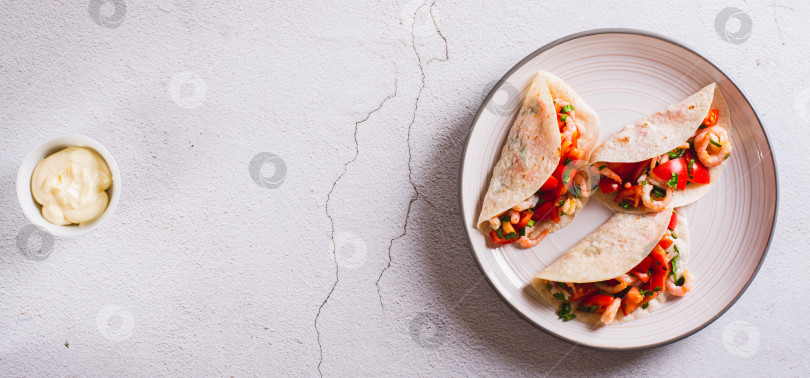 Скачать Мягкая закуска мини-тако с креветками, помидорами и зеленью на тарелке вид сверху веб-баннер фотосток Ozero