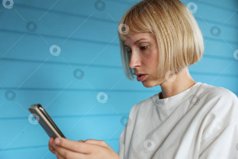 Скачать Молодая женщина, работающая в домашнем офисе. Фрилансер, пользующийся ноутбуком, телефоном и Интернетом. фотосток Ozero