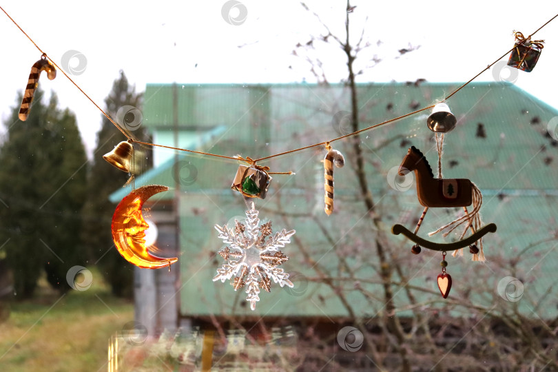 Скачать Новогоднее окно с гирляндой из елочных игрушек фотосток Ozero