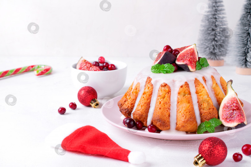 Скачать Рождественский пирог, покрытый глазурью, инжиром, клюквой и мятой, подается на блюде. фотосток Ozero
