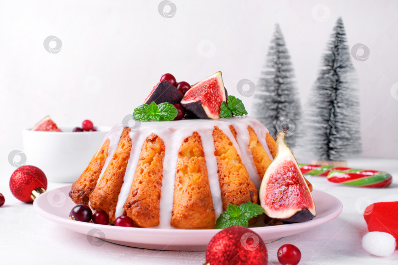 Скачать Рождественский пирог, покрытый глазурью, инжиром, клюквой и мятой, подается на блюде. фотосток Ozero