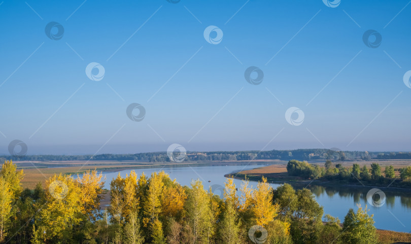 Скачать голубая река между полями и осенними деревьями на фоне голубого неба фотосток Ozero