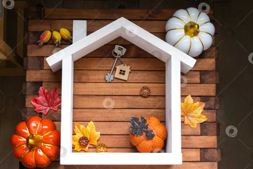 Скачать Уютный макет на деревянном фоне из реек с тыквами, осенними листьями, домиком и ключами - осеннее настроение, Хэллоуин, жилье, переезд, ипотека, страховка. фотосток Ozero