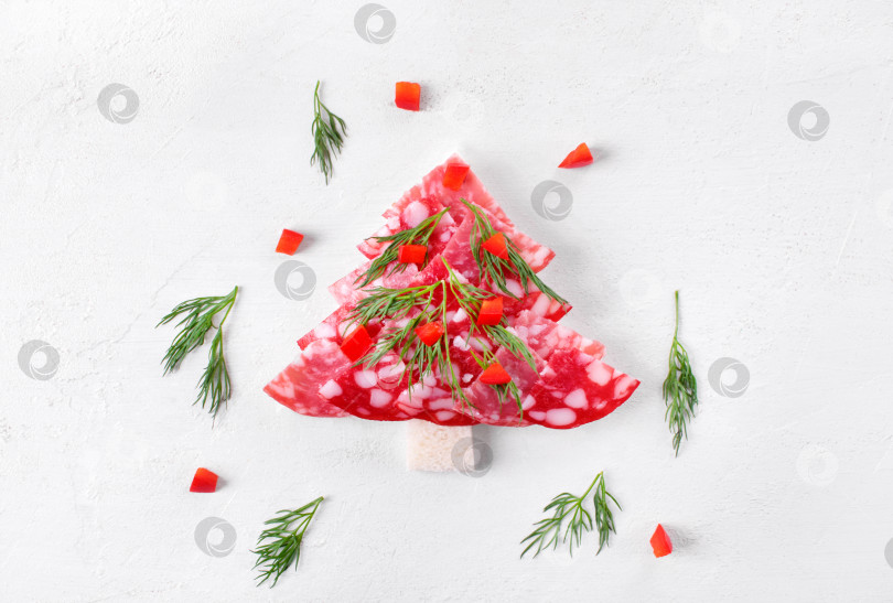 Скачать Канапе "Рождественская елка" с салями на пшеничном хлебе, посыпанном укропом и перцем, на белом столе. Вид сверху. Праздничная закуска. фотосток Ozero