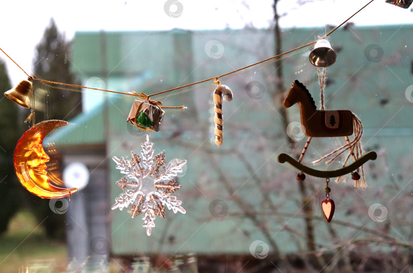 Скачать Новогодняя гирлянда из елочных игрушек на окне фотосток Ozero