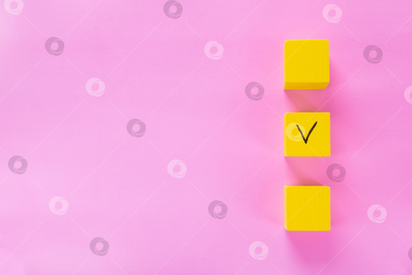 Скачать Три желтых кубика с галочкой на одном на розовом. Пространство для копирования. фотосток Ozero