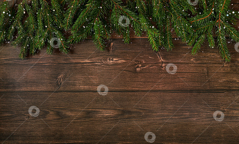 Скачать Фон на Рождество и Новый год 2024 с еловыми ветками, покрытыми снежинками, на деревянном столе, игрушки и украшения, баннер для праздничного экрана, шаблон для дизайна. Праздничная открытка фотосток Ozero