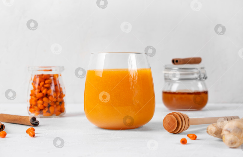 Скачать Облепиховый смузи с имбирем, медом и корицей в стакане для питья фотосток Ozero