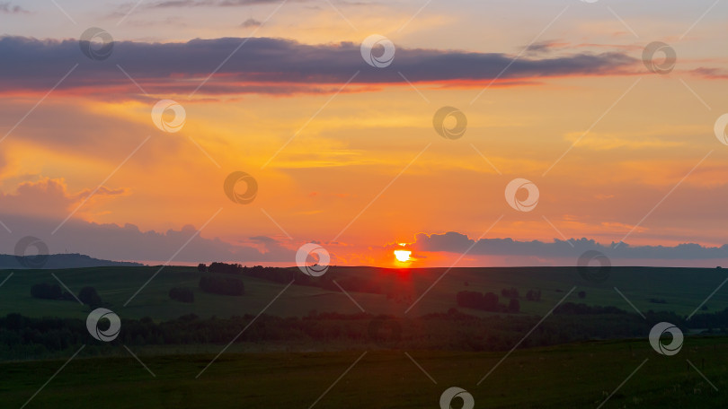 Скачать Закат над горизонтом на фоне оранжевого неба. фотосток Ozero
