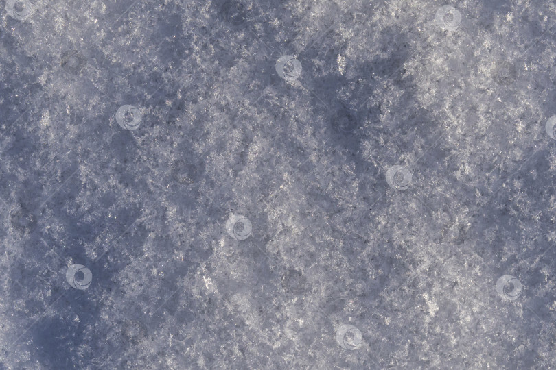 Скачать Макросъемка заснеженной земли, снежинок в холодный зимний день. Снежный покров крупным планом - это абстрактный природный фон. Текстура блестящего снежного покрова фотосток Ozero