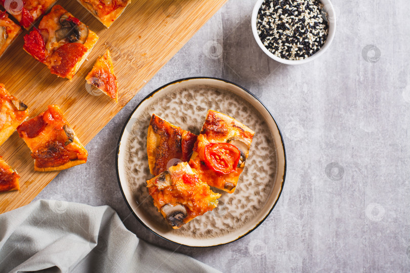 Скачать Кусочки пиццы по-Сент-Луисски с беконом, грибами, помидорами и перцем на тарелке вид сверху фотосток Ozero