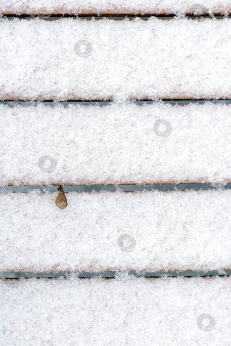 Скачать Абстрактный зимний фон. Крупный план снега на досках скамейки. Вертикально фотосток Ozero