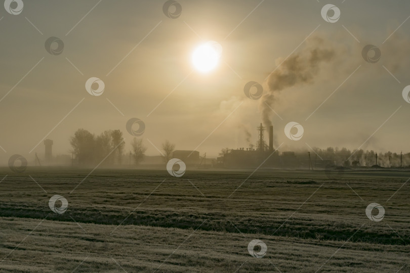 Скачать Вид на работающий завод туманным утром фотосток Ozero