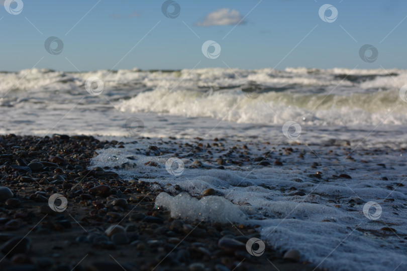 Скачать Морская пена на галечном пляже фотосток Ozero