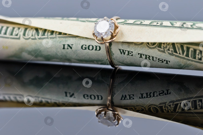 Скачать пятидесятидолларовая купюра вставлена в элегантное женское золотое кольцо фотосток Ozero