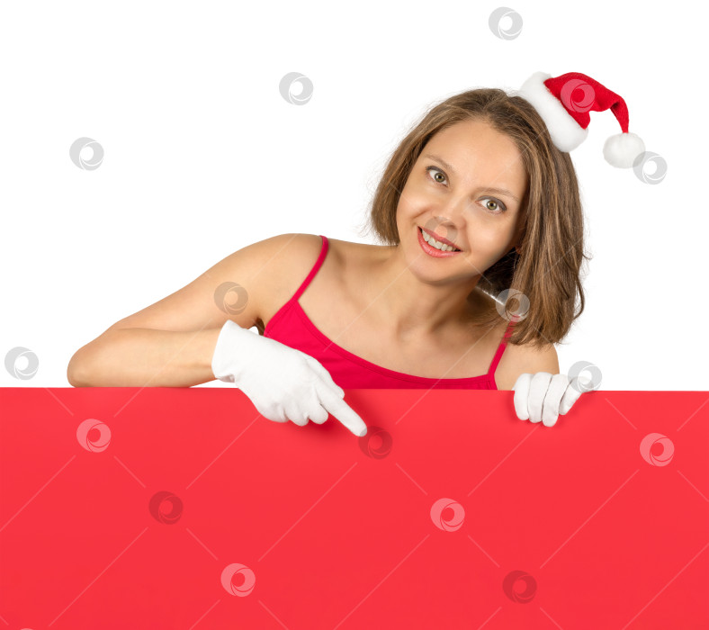 Скачать Улыбающаяся девушка в шапочке Деда Мороза держит красную пустую вывеску для рекламы фотосток Ozero