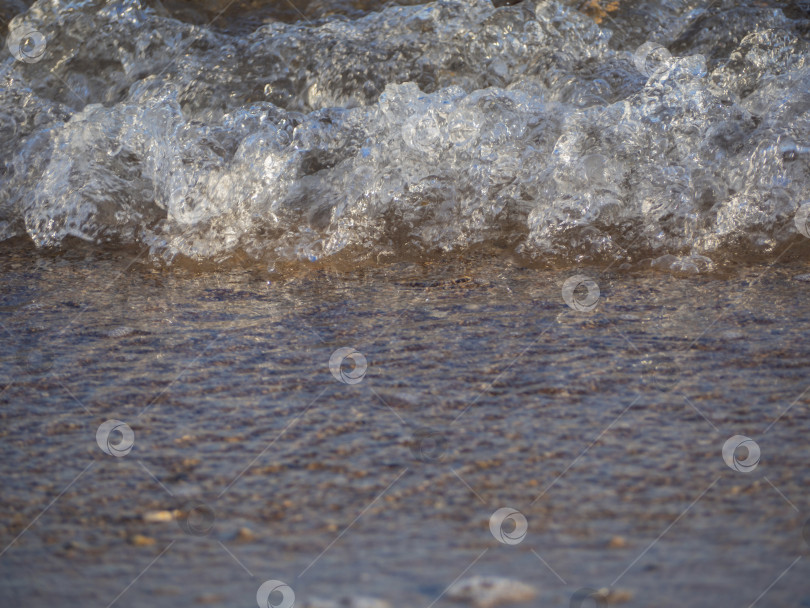 Скачать Крупный план небольшой волны, набегающей на берег. фотосток Ozero