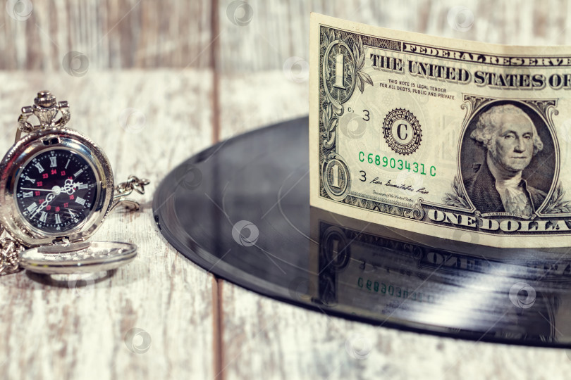 Скачать Долларовая банкнота лежит на старой виниловой пластинке с музыкой фотосток Ozero