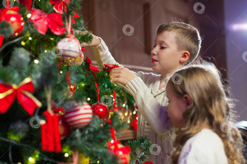Скачать Портрет счастливых детей, украшающих рождественскую елку.Семья, рождество, зима, счастье и концепция людей. фотосток Ozero