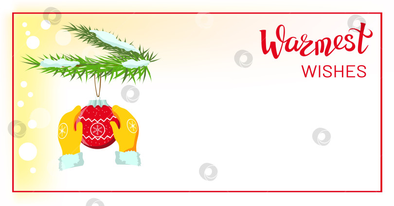 Скачать Руки в желтых варежках, перчатки, держащие красную рождественскую безделушку, украшение рождественского бала, висящее на заснеженных ветвях рождественской елки фотосток Ozero