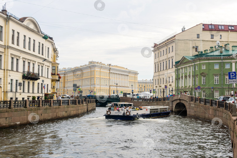 Скачать водный автобус маневрирует на реке Мойке в Санкт-Петербурге перед проездом под низким мостом фотосток Ozero