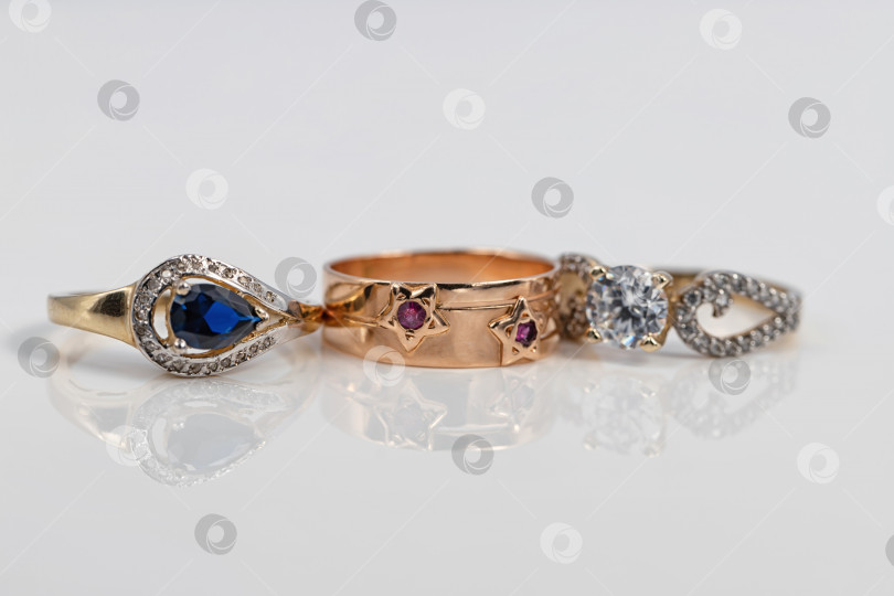 Скачать Три женских золотых кольца разной формы и с разными драгоценными камнями фотосток Ozero