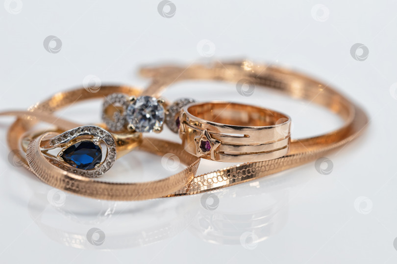 Скачать Три женских золотых кольца разной формы с разными драгоценными камнями и элегантная золотая цепочка фотосток Ozero