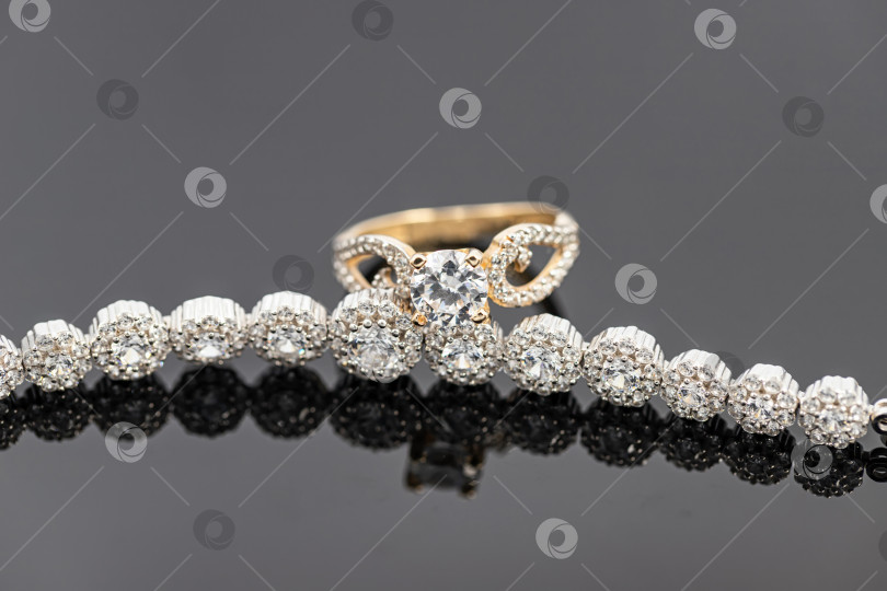 Скачать Элегантное женское золотое кольцо с бриллиантом надето на браслет с драгоценными камнями фотосток Ozero