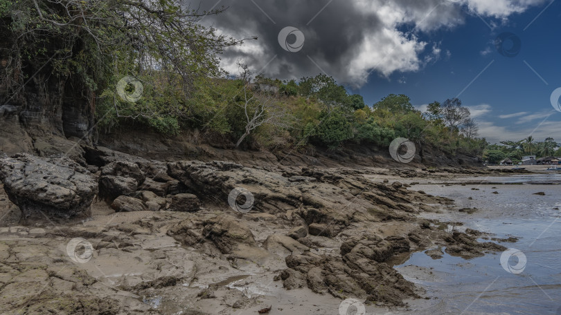 Скачать Скалы морского дна обнажались в прибрежной зоне во время отлива. фотосток Ozero