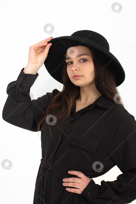 Скачать Девушка в черной шляпе позирует и улыбается на белом фоне фотосток Ozero