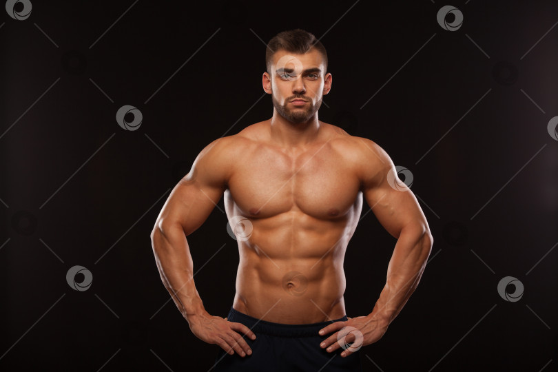 Скачать Сильный спортивный Мужчина - Фитнес-модель, демонстрирующая свой торс с шестью кубиками пресса. изолированный на черном фоне с copyspace фотосток Ozero
