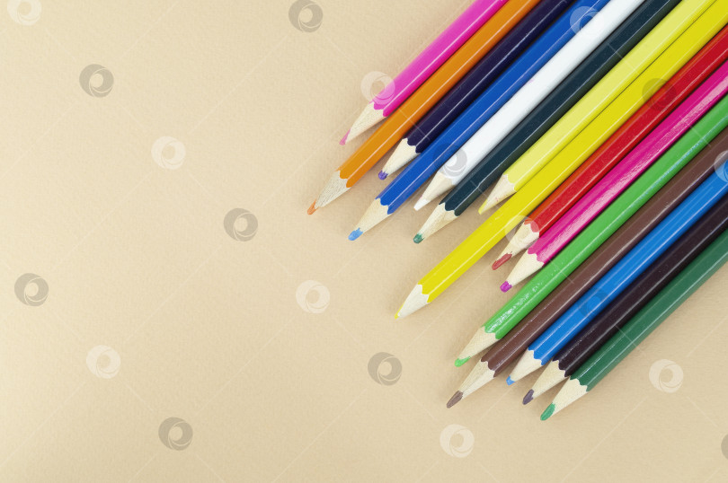 Скачать Множество разноцветных карандашей на приятном бежевом фоне фотосток Ozero