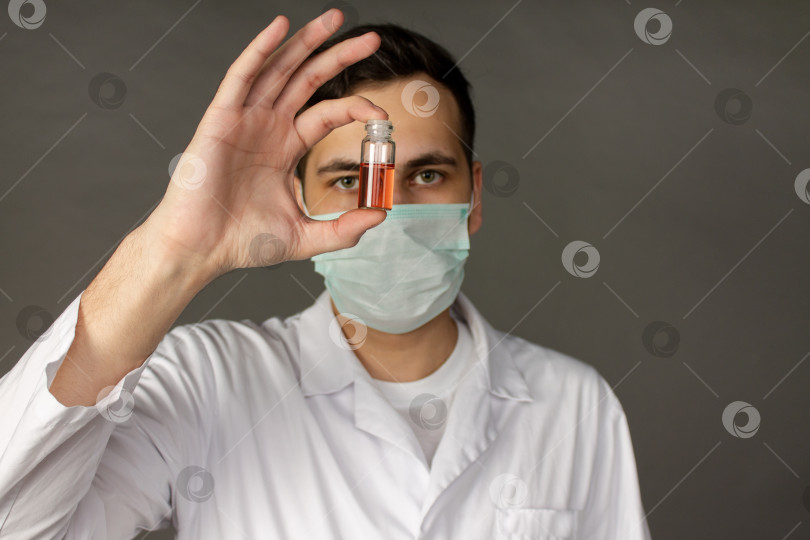 Скачать Медицинский работник держит в руках вакцину против смертельного вируса фотосток Ozero