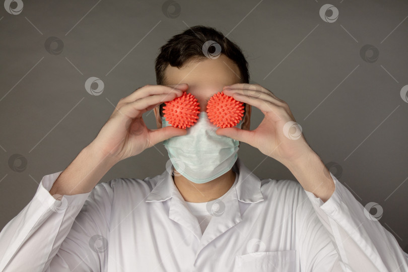 Скачать Медицинский работник держит в руках модель коронавируса. фотосток Ozero