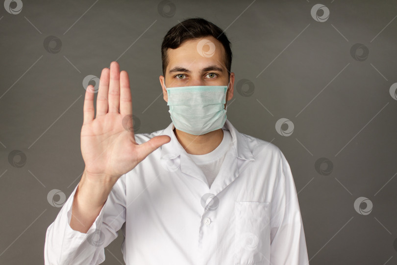 Скачать Портрет врача в медицинском халате, хватающегося за голову из-за количества пациентов с коронавирусом. фотосток Ozero